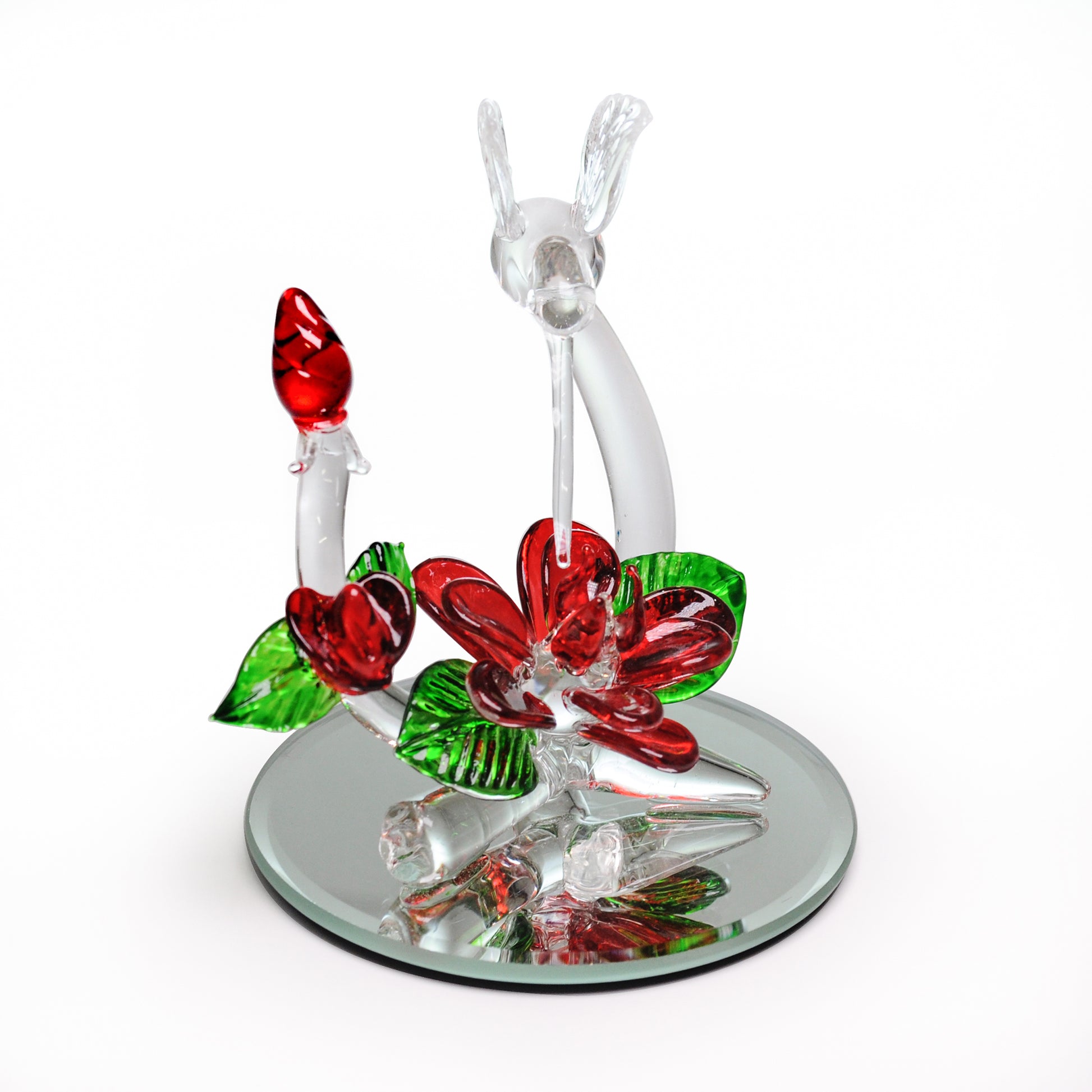 Crystal Castle Hummingbird flying over red and green glass flowers and flowers buds on a mirror base. Front View