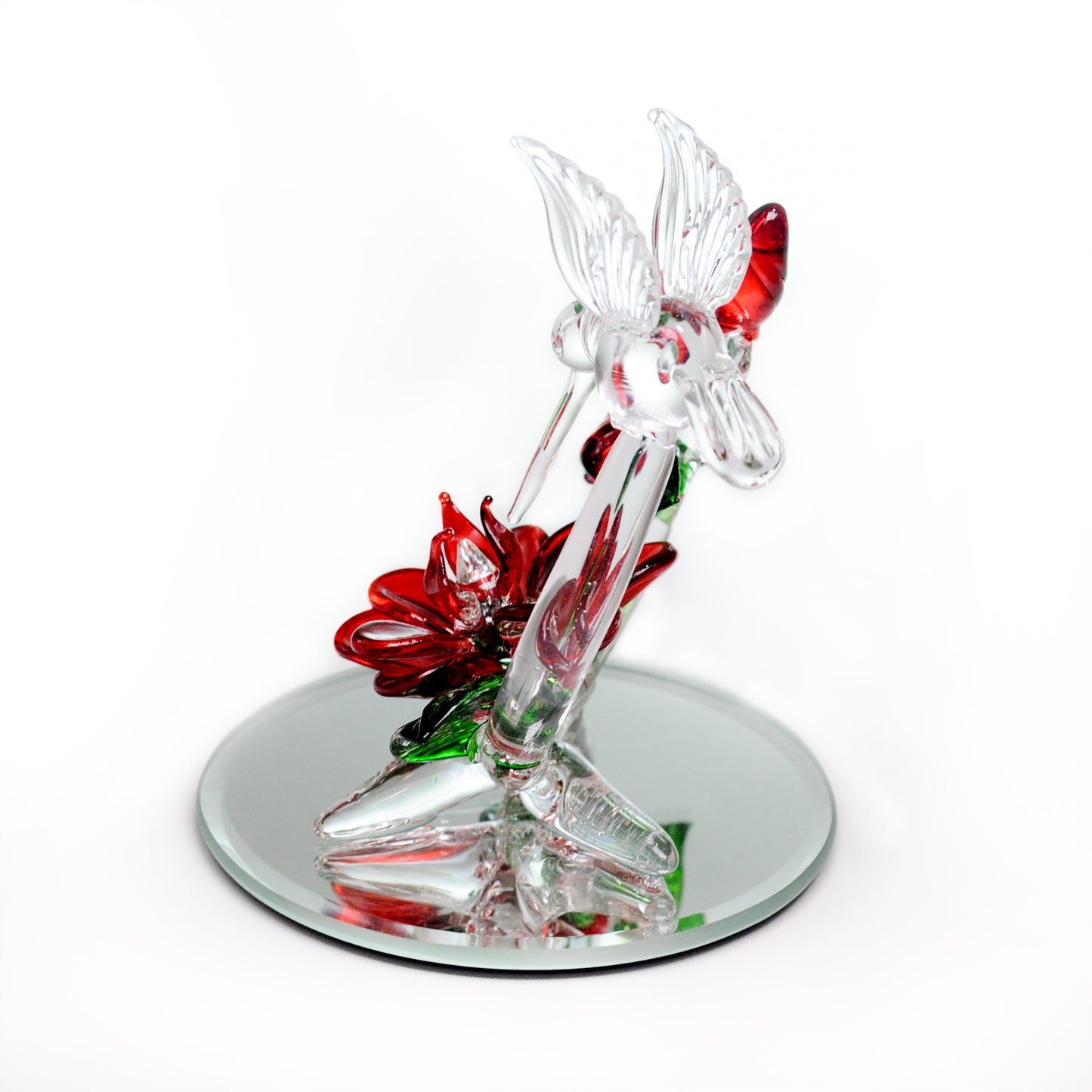 Crystal Castle Hummingbird flying over red and green glass flowers and flowers buds on a mirror base. Back View.