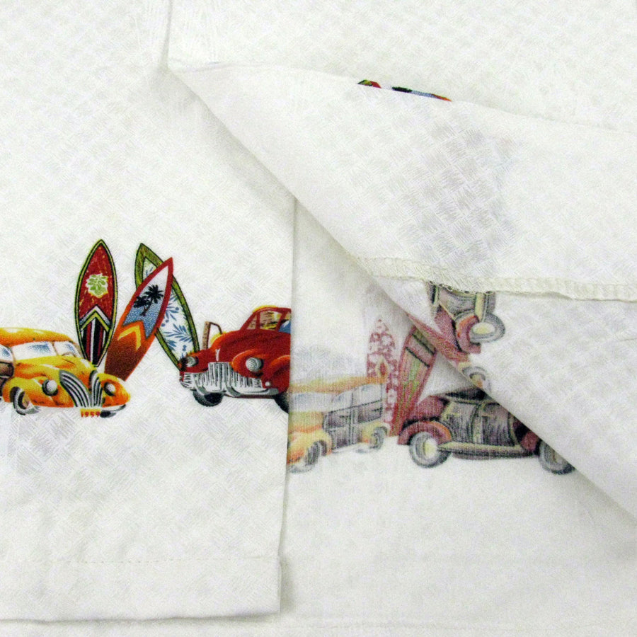 Model wearing High Surf Men's Hawaiian Shirt depicting Palm Trees, Cars and Surfboards in White. Close up of fabric.